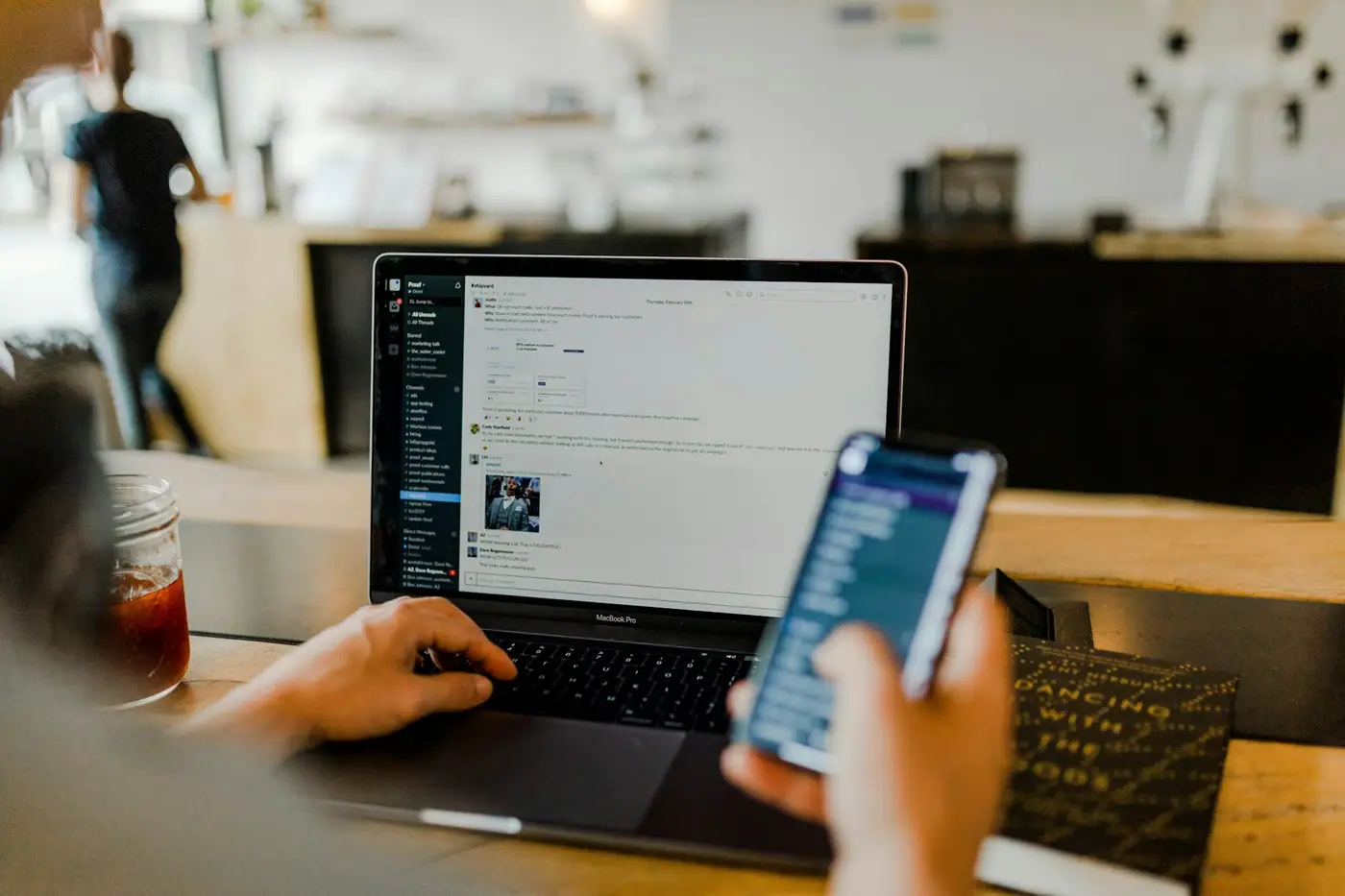 Celular con contenido de redes sociales junto a una laptop