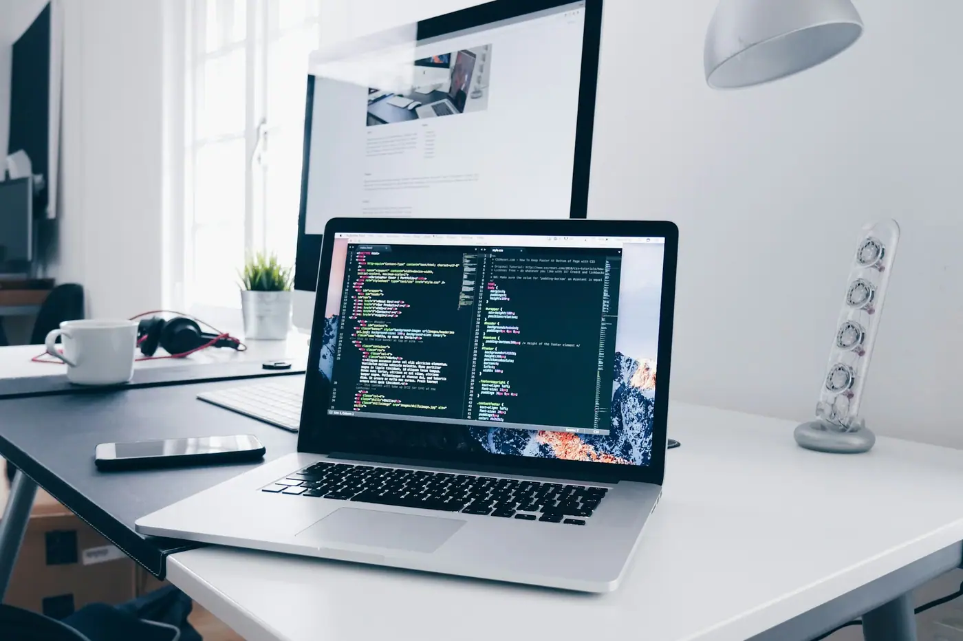 Laptop con código de programación abierto en un escritorio luminoso